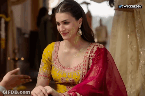 A Woman In A Yellow And Pink Dress With A Wickreddy Watermark On The Bottom Right GIF