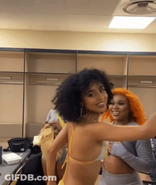 A Woman In A Yellow Bikini Is Standing Next To Another Woman With Orange Hair GIF
