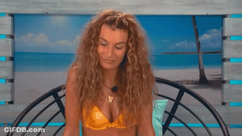 A Woman In A Yellow Bikini Sits On A Chair GIF