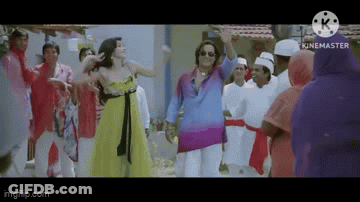 A Woman In A Yellow Dress Is Dancing With A Man In A Blue Shirt In Front Of A Crowd Of People . GIF
