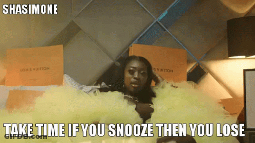 A Woman In A Yellow Dress Is Laying On A Bed With Louis Vuitton Boxes Behind Her GIF
