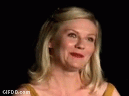 A Woman In A Yellow Dress Is Making A Funny Face In A Dark Room . GIF