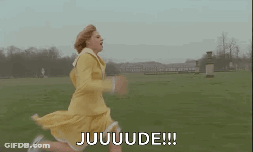 A Woman In A Yellow Dress Is Running In A Field And Saying Juuuuuude . GIF