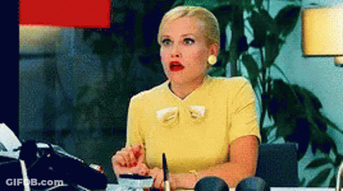 A Woman In A Yellow Dress Is Sitting At A Desk With A Pen In Her Hand GIF