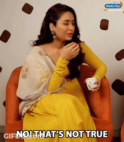 A Woman In A Yellow Dress Is Sitting In An Orange Chair With The Words No That 'S Not True GIF