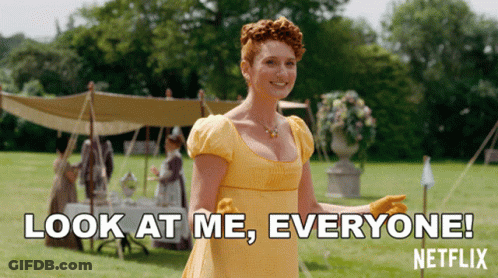 A Woman In A Yellow Dress Is Standing In A Field And Says Look At Me Everyone Netflix GIF