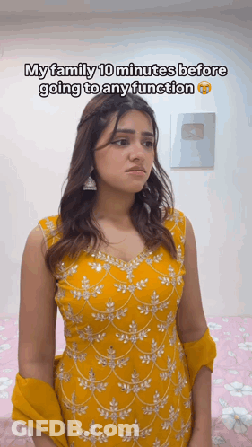A Woman In A Yellow Dress Is Standing In Front Of A Sign That Says My Family 10 Minutes Before Going To Any Function GIF