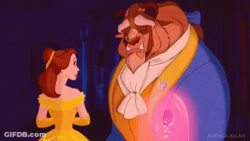 A Woman In A Yellow Dress Is Standing Next To A Man In A Blue Suit . GIF