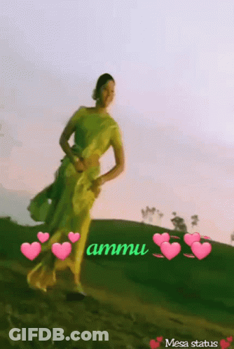 A Woman In A Yellow Dress Is Standing On A Hill With Hearts Around Her And The Words Ammu Written On The Bottom GIF