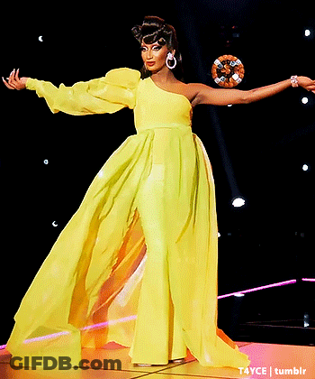 Woman In Yellow Dress On Stage With Arms Out GIF