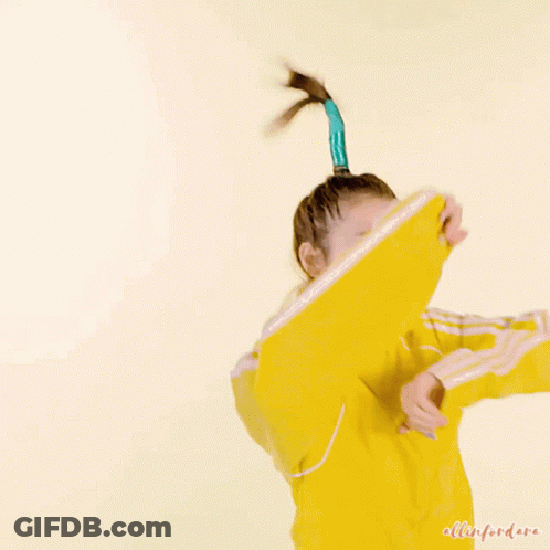 A Woman In A Yellow Jacket Has A Blue Ponytail In Her Hair GIF