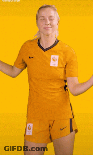 A Woman In A Yellow Nike Shirt And Shorts Is Dancing On A Yellow Background GIF