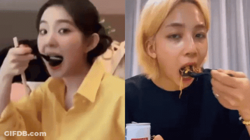 A Woman In A Yellow Shirt Is Eating Noodles With A Fork . GIF