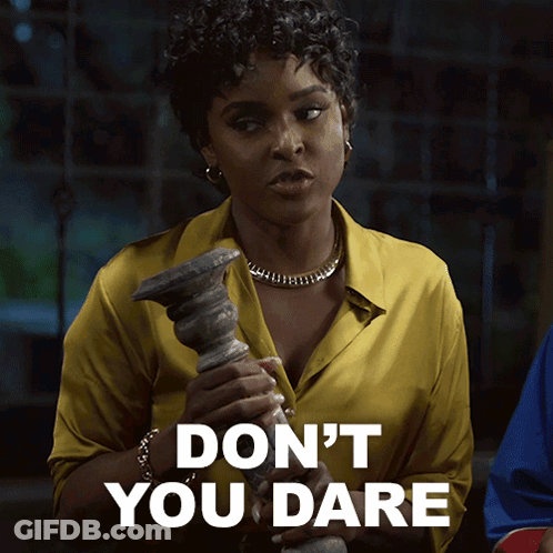 A Woman In A Yellow Shirt Is Holding A Candle Holder And Says " Don 'T You Dare " GIF