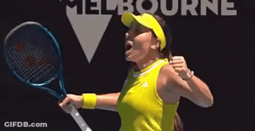A Woman In A Yellow Shirt Is Holding A Tennis Racquet And Celebrating . GIF