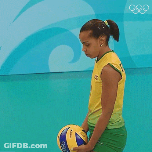A Woman In A Yellow Shirt Is Serving A Volleyball In Front Of A Sign That Says B GIF