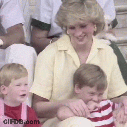 A Woman In A Yellow Shirt Is Sitting With Two Children And A Dog . GIF
