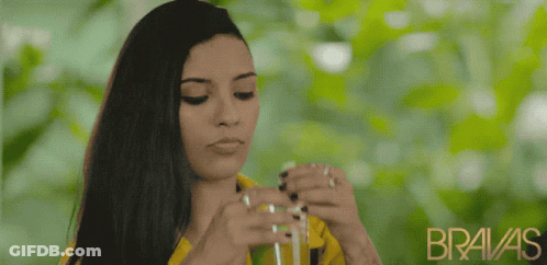 A Woman In A Yellow Shirt With The Word Bravas On The Bottom GIF