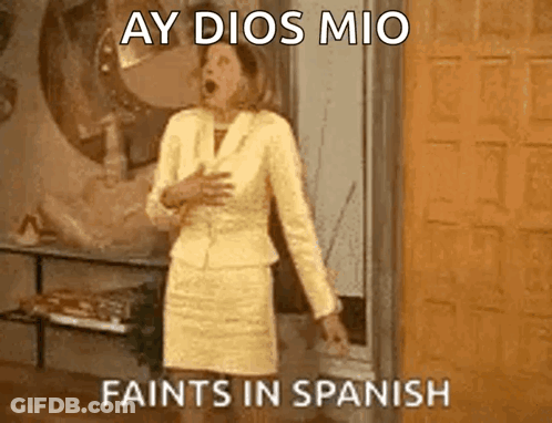 A Woman In A Yellow Suit Is Standing In Front Of A Door With Her Mouth Open And The Words Ay Dios Mio Faints In Spanish GIF
