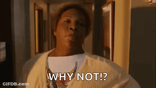 A Woman In A Yellow Sweater Is Standing In A Hallway And Saying `` Why Not ? '' GIF
