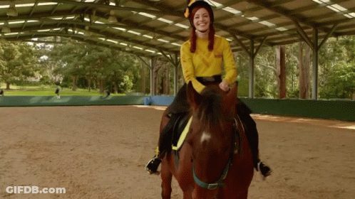 A Woman In A Yellow Sweater Riding A Brown Horse GIF
