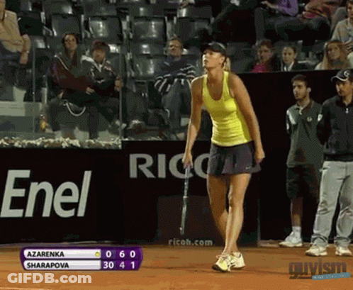 A Woman In A Yellow Tank Top Is Holding A Tennis Racquet In Front Of A Sign That Says Enel GIF