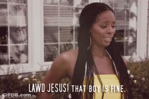 A Woman In A Yellow Tank Top Is Standing In Front Of A Window And Saying Lawd Jesus That Boy Is Fine . GIF