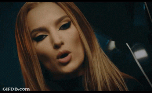 A Woman In A Zebra Print Shirt Touches A Large Screen GIF