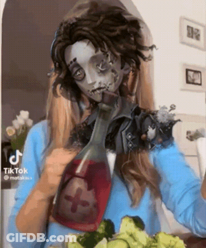 A Woman In A Zombie Costume Is Drinking From A Bottle While Eating Vegetables . GIF