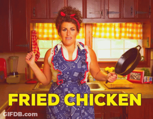 A Woman In An Apron Is Holding A Frying Pan In A Kitchen With The Words Fried Chicken Written In Yellow GIF