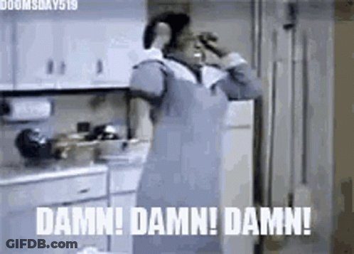 A Woman In An Apron Is Standing In A Kitchen Talking On A Cell Phone And Making A Funny Face . GIF