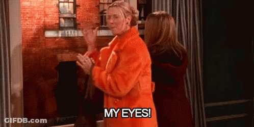 A Woman In An Orange Coat Is Standing Next To A Woman In A Red Coat And Says `` My Eyes ! '' GIF