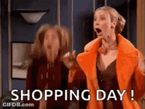 A Woman In An Orange Coat Is Standing Next To Another Woman In A Room . GIF