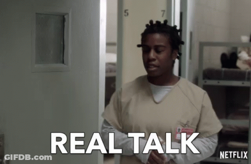 A Woman In An Orange Scrub Stands In Front Of A Door That Says Real Talk Netflix GIF