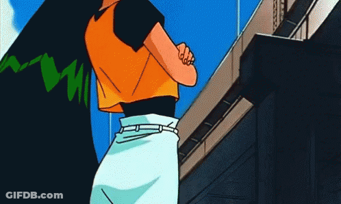 A Woman In An Orange Shirt And White Skirt Stands In Front Of A Building GIF