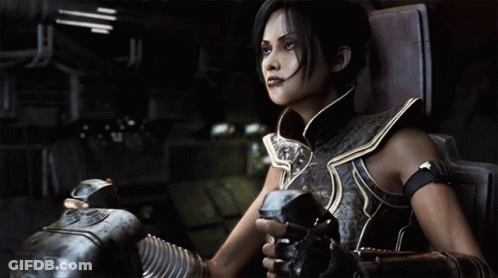 A Woman In Armor Is Sitting In A Chair Holding A Gun GIF