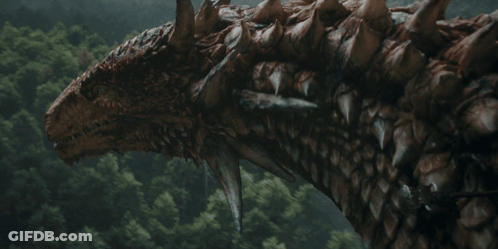 A Woman In Armor With A Crown On Her Head Smiles GIF