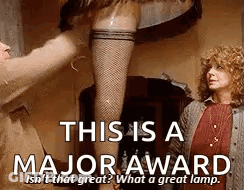A Woman In Fishnet Stockings Is Standing Next To A Man In A Brown Jacket . GIF