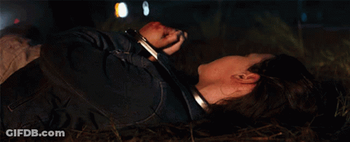 A Woman In Handcuffs Laying On The Ground GIF