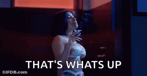 A Woman In Lingerie Is Smoking A Cigarette In A Dark Room . GIF
