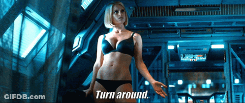 A Woman In Lingerie Is Standing In A Room With The Words Turn Around Behind Her GIF