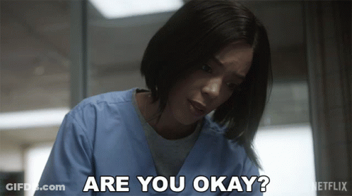 A Woman In Scrubs Is Asking If She Is Okay GIF