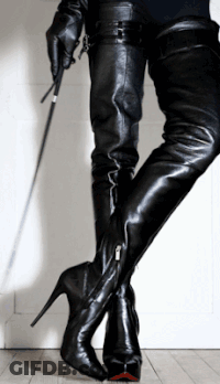 A Woman In Thigh High Boots Holds A Whip In Her Hand GIF