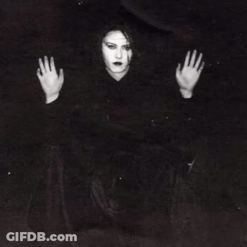 A Woman Is Behind Bars In A Jail Cell With Her Hands Behind The Bars . GIF