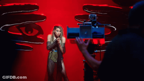 A Woman Is Being Filmed In Front Of A Camera GIF