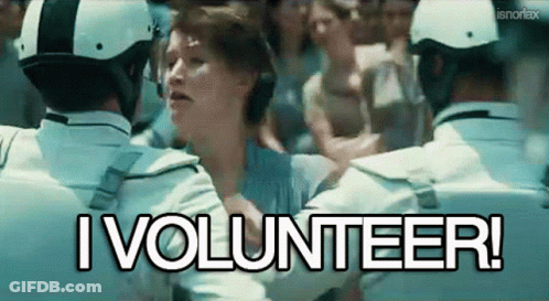 A Woman Is Being Held By A Group Of Police Officers With The Words I Volunteer Written Above Her GIF