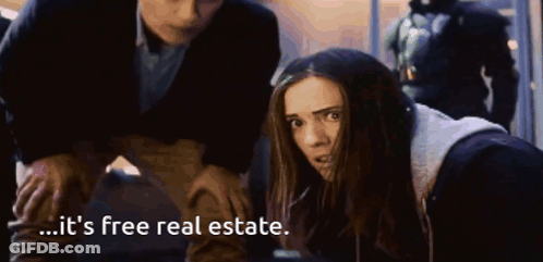 A Woman Is Being Held By A Man And Says It 'S Free Real Estate . GIF