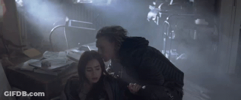 A Woman Is Being Held By A Man In A Dark Room GIF