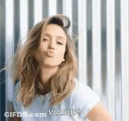 A Woman Is Blowing A Kiss While Wearing A White T-Shirt . GIF