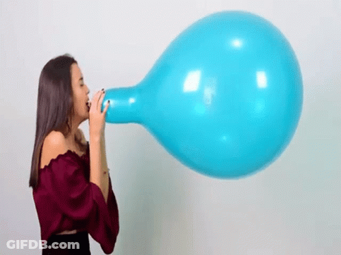 A Woman Is Blowing Up A Large Blue Balloon With Her Mouth . GIF